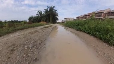 İnşaat alanının kırsal kesimine uzanan kırsal bakış açısı boyunca uzanan su birikintisinin görüntüsü..
