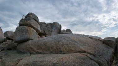 Kumlu sahil sahnesinin yanında ya da yanında büyük kaya yığınları bulundu..