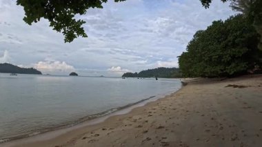 Perak, Malezya. 30 Aralık 2025: Pangkor Adası 'ndaki kumlu sahilde ya turistlerin ya da insanların dinlenme etkinliği.