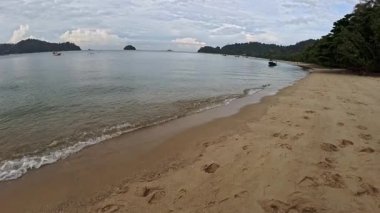 Perak, Malezya. 30 Aralık 2025: Pangkor Adası 'ndaki kumlu sahilde ya turistlerin ya da insanların dinlenme etkinliği.