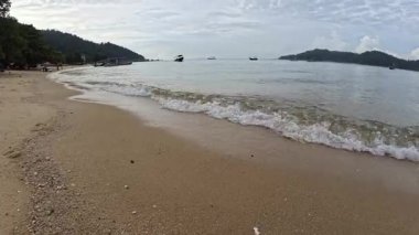 Perak, Malezya. 30 Aralık 2025: Pangkor Adası 'ndaki kumlu sahilde ya turistlerin ya da insanların dinlenme etkinliği.