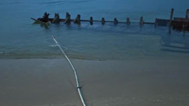Sadece ahşap iskeleti olan, deniz kıyısında terk edilmiş bir tekne..