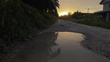 Güzel günbatımı gökyüzü huzurlu kırsal yolda durgun su havuzunun yanında..