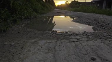 Güzel günbatımı gökyüzü huzurlu kırsal yolda durgun su havuzunun yanında..