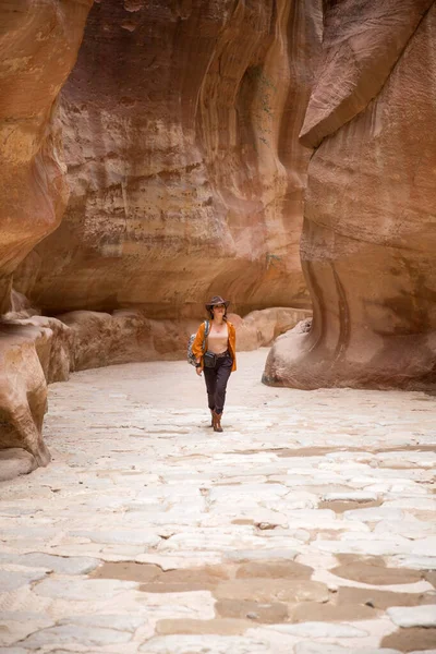 Turista chica con una mochila en un sombrero de vaquero camina por el fondo del cañón — Foto de Stock