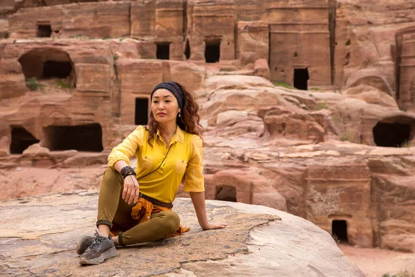 Una joven turista se sienta en una piedra cerca de la antigua ciudad — Foto de Stock