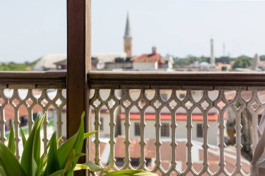 Eski kasabanın balkon korkuluklarından bak. Çit odaklı, şehir bulanık..