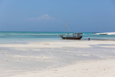 Zanzibar, Tanzanya, 18 Ocak 2021: Bir balıkçı teknesi, gök mavisi denizin arka planına karşı kıyıya vuruyor ve karaya vuruyor.