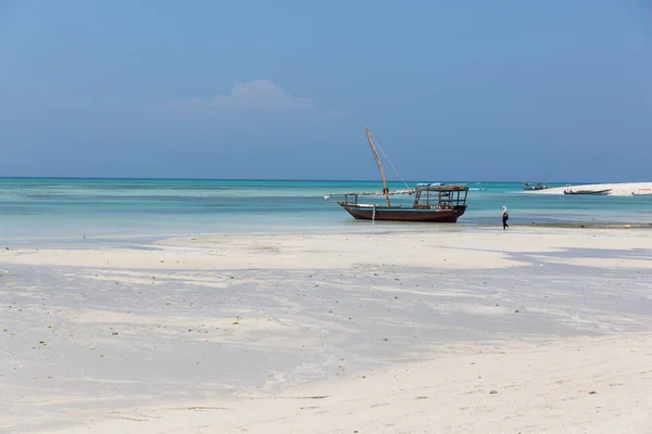 Zanzibar, Tanzanie, 18. ledna 2021: Rybářský člun kotví na mělčině za odlivu na pozadí azurového moře. — Stock fotografie