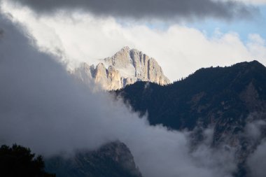 Yeşil bulutlar arasında dramatik bir dolomit kayası