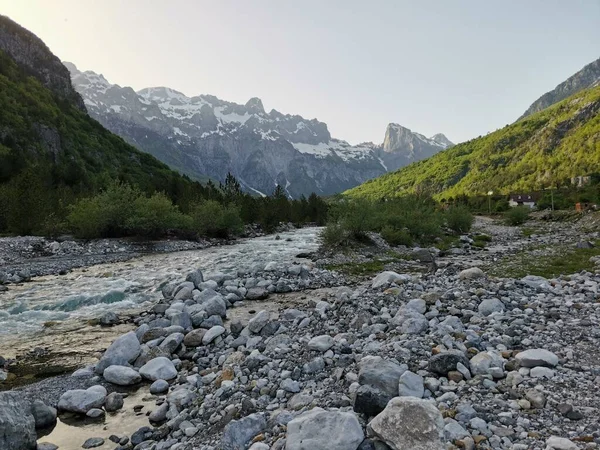 cold mountain river in theth valley in the albanian alps in spring 2021 with snow caped mountains and good weather