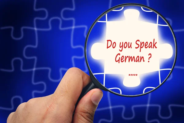 Taler du tysk? Forstørrelsesglas og puslespil . - Stock-foto