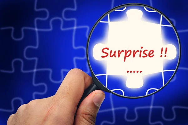 Surprise word. Magnifier and puzzles. — Stock Photo, Image