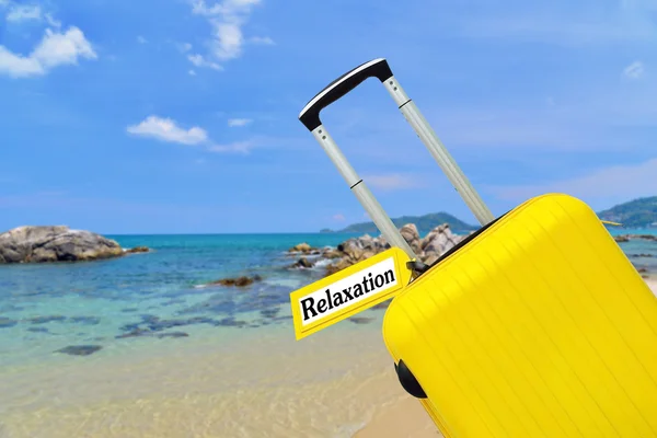 Relajación. maleta con etiqueta en el mar . —  Fotos de Stock
