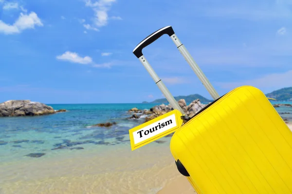 Tourism. Suitcase with label at sea. — Stock Photo, Image