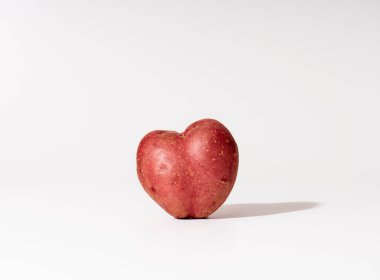 Beyaz arkaplandaki çirkin kalp şekilli patatesler..