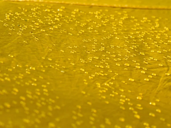 防水膜织物上的水滴 黄色合成防水布纹理的详细视图 帐篷上的晨露 — 图库照片