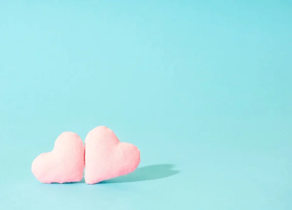 Mavi arka planda el yapımı pembe kalpler..