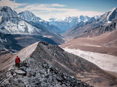 Yalnız dağcı sisin içinde karlı dağa tırmanıyor.