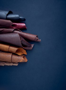 Koyu arkaplanda çeşitli renklerde deri tekstil örnekleri