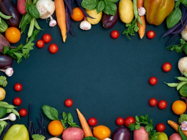 Koyu arka planda çeşitli sebzelerin çerçevesi, üst görünüm.