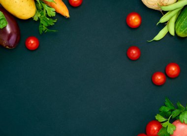 Koyu arka planda çeşitli sebzelerin çerçevesi, üst görünüm.