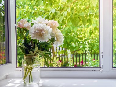 Pencere kenarındaki vazoda şakayık demeti.