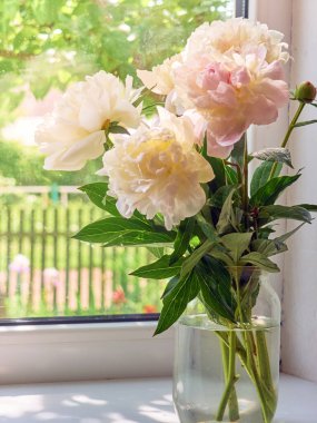 Pencere kenarındaki vazoda şakayık demeti.