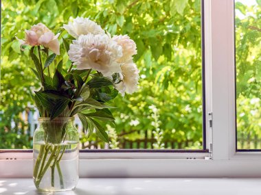 Pencere kenarındaki vazoda şakayık demeti.