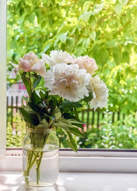 Pencere kenarındaki vazoda şakayık demeti.