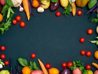 Koyu arka planda çeşitli sebzelerin çerçevesi, üst görünüm.