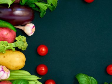 Koyu arka planda çeşitli sebzelerin çerçevesi, üst görünüm.