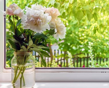 Pencere kenarındaki vazoda şakayık demeti.