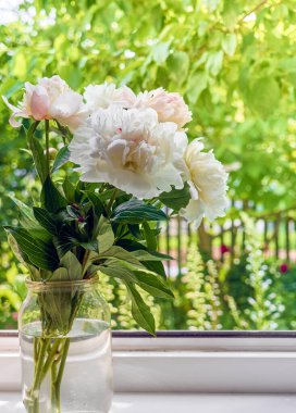 Pencere kenarındaki vazoda şakayık demeti.