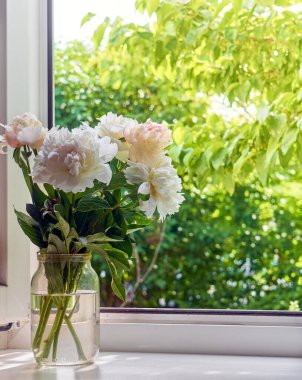 Pencere kenarındaki vazoda şakayık demeti.