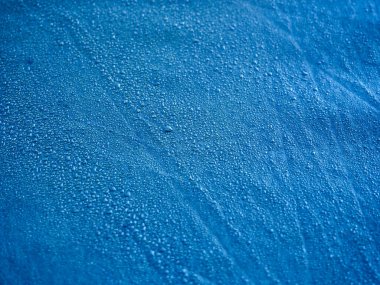 Su geçirmez zar kumaşına su damlıyor. Mavi sentetik su geçirmez kumaşın detaylı görünümü. Çadırda sabah çiği.