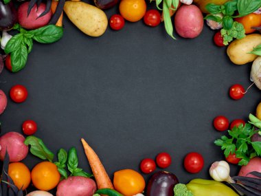 Koyu arka planda çeşitli sebzelerin çerçevesi, üst görünüm.