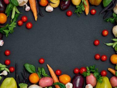 Koyu arka planda çeşitli sebzelerin çerçevesi, üst görünüm.