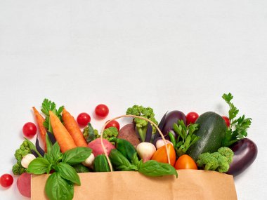 Beyaz arka planda kağıt torbalarda sebzeler.