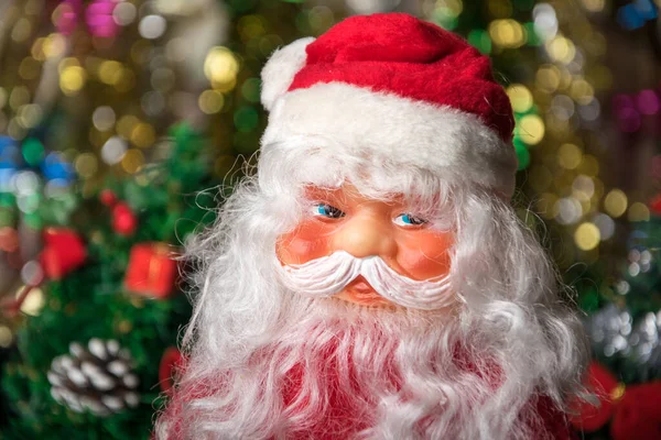 Oyuncak Noel Baba 'nın portresi. Parlayan Noel çelenklerinin çözülmüş arka planında..