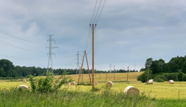 Yüksek gerilim hattı saman rulolarının olduğu bir alandan geçer..