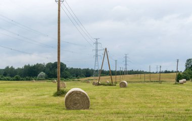 Yüksek gerilim hattı saman rulolarının olduğu bir alandan geçer.