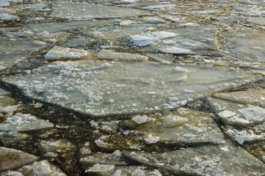 Manzaraya yakın buzlar, güneşli bir günde, kışın sonunda nehre sürükleniyor.,