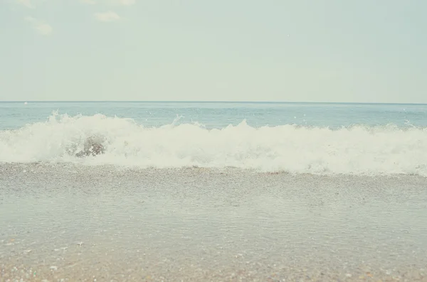 Волна катится по песчаному пляжу — стоковое фото