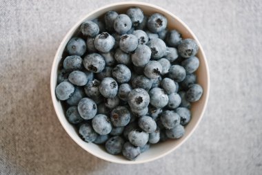 Tabak taze yaban mersiniyle dolu, yukarıdan manzaralı. İçinde su damlaları olan küçük tatlı meyveler. Yaz meyveleri masada. Doğal vitamin kaynağı