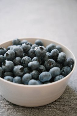 Taze olgun yaban mersini dolu beyaz tabak. Tatlı böğürtlen, sağlıklı tatlı. Sabah masadaki yaz meyveleri. Doğal vitamin kaynağı, sağlıklı beslenme.