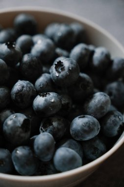 Bir damla suyla kaplı tatlı olgun yaban mersini. Tabakta taze böğürtlen dokusu. Masada bir sürü yaz meyvesi var. Doğal vitamin kaynağı, sağlıklı beslenme.