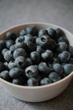 İzole edilmiş su damlalarıyla kaplı olgun yaban mersinleri. Tabakta taze böğürtlen dokusu. Masada bir sürü karanlık yaz meyvesi var. Doğal vitamin kaynağı, sağlıklı beslenme.
