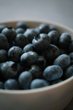 Yenmeye hazır su damlalarıyla kaplı tatlı olgun yaban mersini makrosu. Taze böğürtlenler tabakta. Masada bir sürü yaz meyvesi var. Doğal vitamin kaynağı, sağlıklı beslenme.