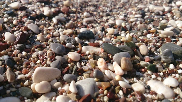 Many small pebbles in the surf line — Stock Photo, Image